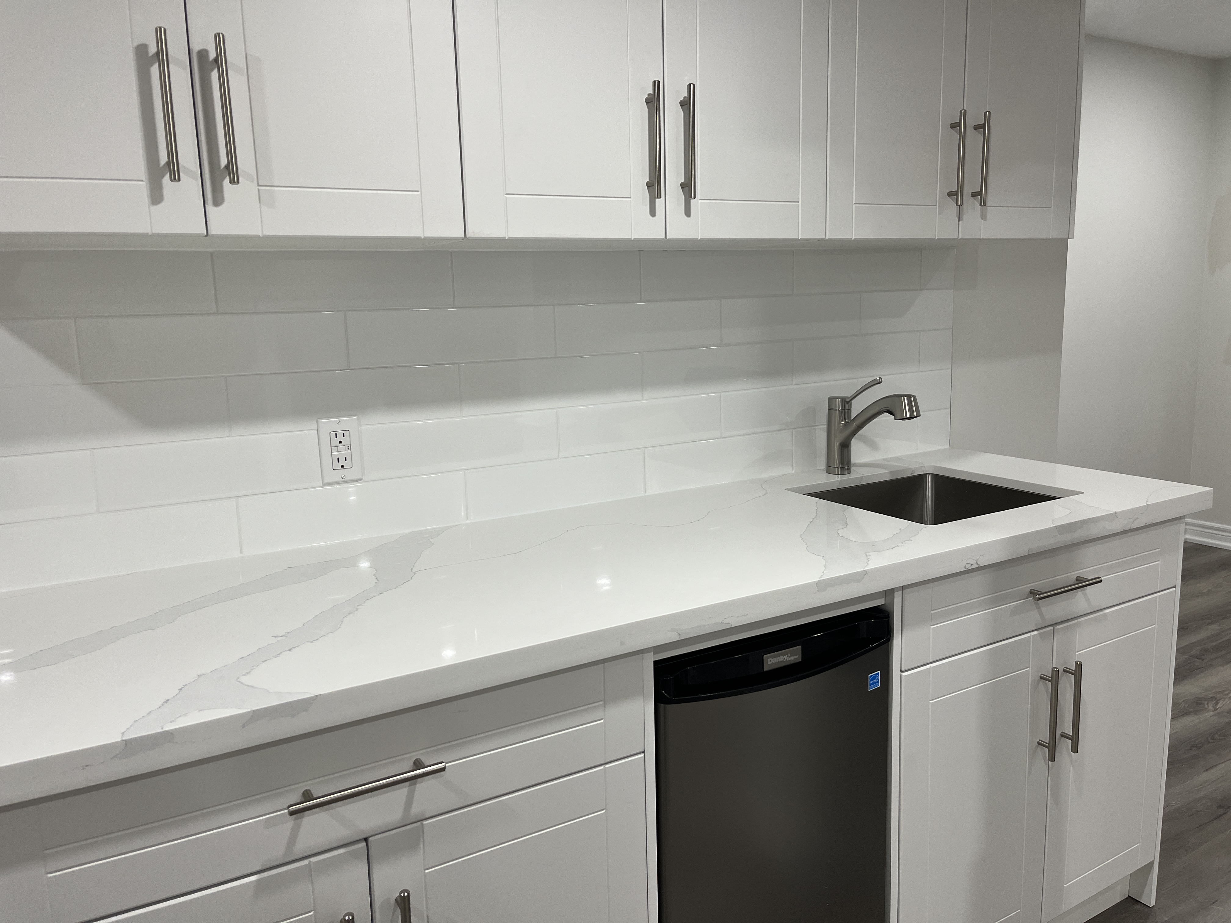 Image of A bathroom wiht a his and hers vanity, large tub, and wrap-around half-tiled walls.